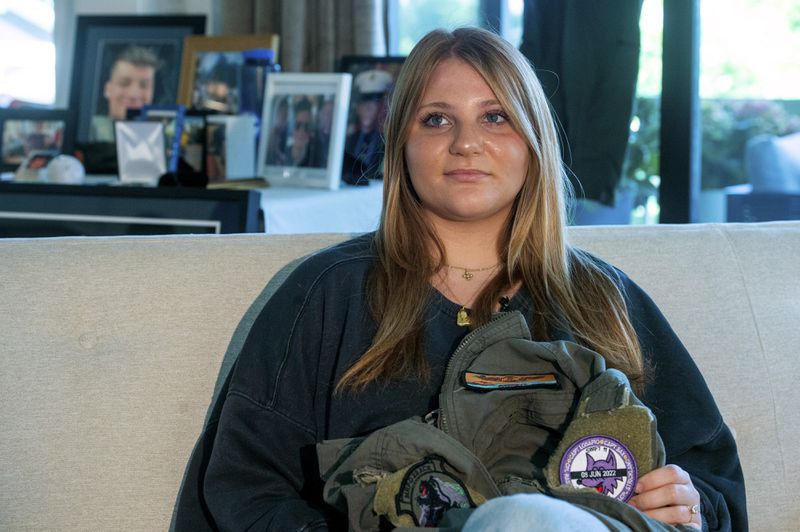 Gwyneth Collart sits for a portrait while holding the uniform of her brother Marine Corporal Spencer R. Collart at her home, in Arlington, Va., Thursday, June 19, 2024. Her brother was killed along with two other Marines when the MV-22B Osprey aircraft they were on crashed during drills on a north Australian island on August 27, 2023. (AP Photo/Rod Lamkey, Jr.)