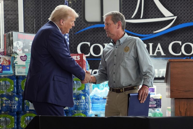 Republican presidential nominee former President Donald Trump shakes hands with Georgia Gov. Brian Kemp at a temporary relief shelter as he visits areas impacted by Hurricane Helene, Friday, Oct. 4, 2024, in Evans, Ga. (AP Photo/Evan Vucci)