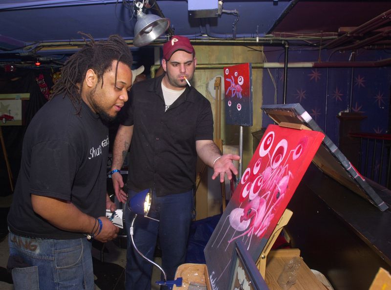 Artist Michi checks out the work of fellow artist Maxwell Sebastian at FunkJazz Kafe at the Tabernacle in March 2004. (LAURA NOEL/STAFF)