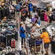 Baggage stored in the Delta’s baggage claim area wait for passengers to claim them. Long lines and baggage stockpiles returned Tuesday, July 23, 2024 as Hartsfield-Jackson International Airport’s new normal. Travelers have been sleeping at the Atlanta airport since the meltdown began Friday with a technology outage that affected Microsoft users around the world.  (John Spink/AJC)