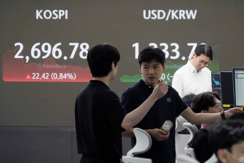 Currency traders work near a screen showing the Korea Composite Stock Price Index (KOSPI), left, and the foreign exchange rate between U.S. dollar and South Korean won at the foreign exchange dealing room of the KEB Hana Bank headquarters in Seoul, South Korea, Tuesday, Aug. 20, 2024. (AP Photo/Ahn Young-joon)