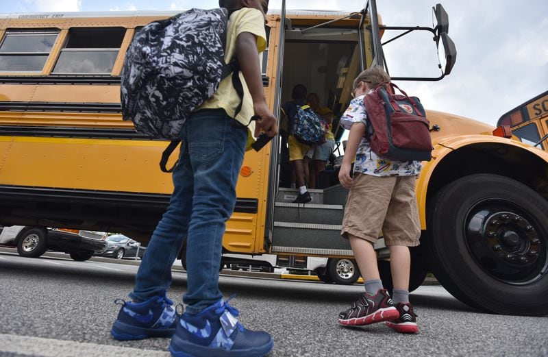 Students board a bus at Burnette Elementary School in Suwanee on Tuesday, August 13, 2019.