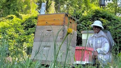 Simone Fyffe is seen here caring for her bee colony. Her business, Art + Honey Co. by PCS LLC, incorporates her two passions - art and bees. (Photo Courtesy of Sydney Sims/Capital B)