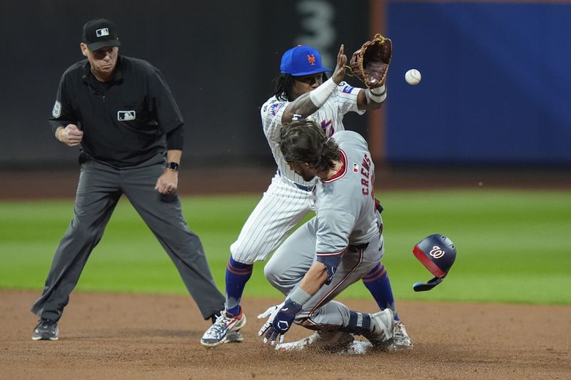 Washington Nationals' Dylan Crews slides past New York Mets' Luisangel Acuna for a double during the second inning of a baseball game, Tuesday, Sept. 17, 2024, in New York. (AP Photo/Frank Franklin II)