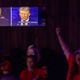 Tiana Robinson cheers at a Republican presidential debate watch party Tuesday at the Adventure Outdoors gun store and indoor shooting range in Smyrna. (Arvin Temkar / AJC)