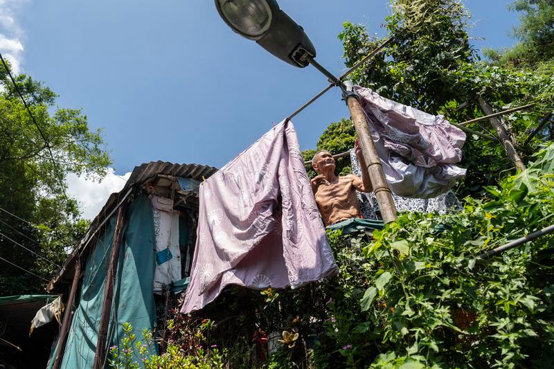 A elderly villager attends to his laundry at the Cha Kwo Ling Village in Hong Kong, Sunday, Aug. 25, 2024. (AP Photo/Chan Long Hei)