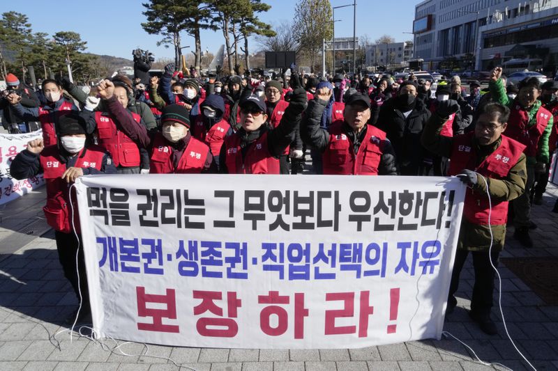 FILE - Dog farmers shout slogans during a rally against the government-led dog meat banning bill in front of the presidential office in Seoul, South Korea on Nov. 30, 2023. The letters read "Guarantee the right to life and freedom of choice of occupation." (AP Photo/Ahn Young-joon, File)