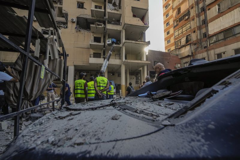 Rescuers check a building that was hit by an Israeli airstrike in Beirut's southern suburbs, Thursday, Sept. 26, 2024. (AP Photo/Hassan Ammar)