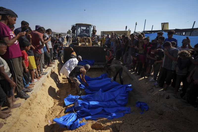 People bury the bodies of Palestinians taken by the Israeli military during operations in Gaza and returned this week, in Khan Younis, Gaza Strip, Thursday, Sept. 26, 2024. (AP Photo/Abdel Kareem Hana)