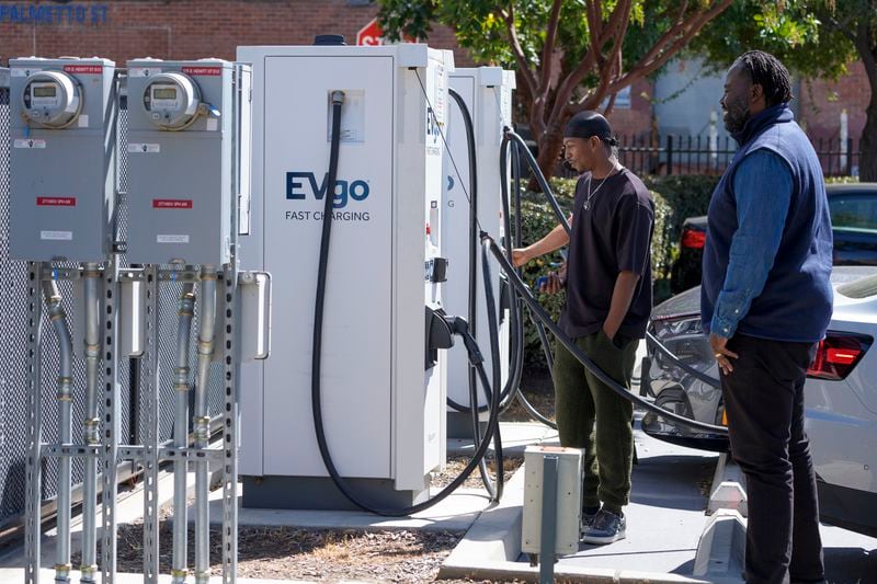 ChargerHelp! Field Service Manager Clyde Ellis, right, talks to James Thomas, a customer charing at a charging station at the La Kretz Innovation Campus in Los Angeles on Thursday, March 14, 2024. (AP Photo/Damian Dovarganes)