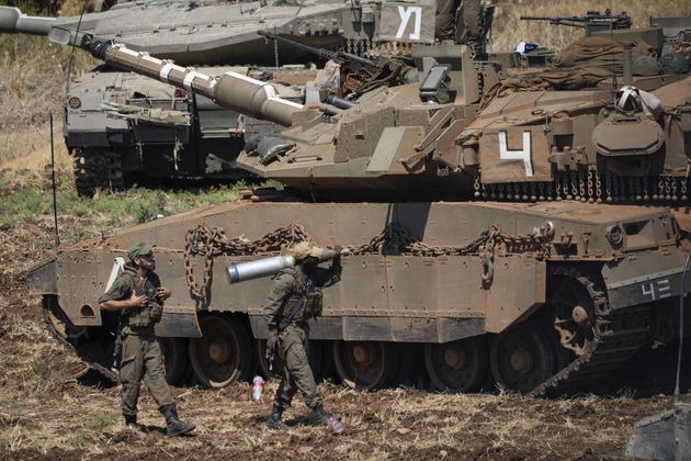 An Israeli soldier carries a shell next to a tank in northern Israel on Friday, Sept. 27, 2024. (AP Photo/Baz Ratner)