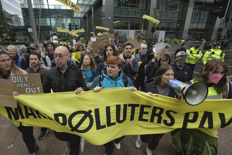 FILE - Environmental activists including Greta Thunberg, center left, marches with other demonstrators during the Oily Money Out protest at Canary Wharf, in London, Oct. 19, 2023. (AP Photo/Kin Cheung, File)