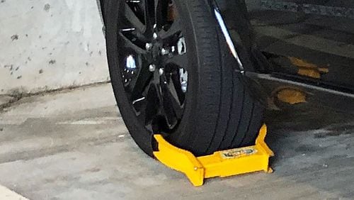 A vehicle booted in a private parking deck in Buckhead. A bill moving through the Georgia Legislature would make it all-but-illegal to use booting as a method of parking enforcement.