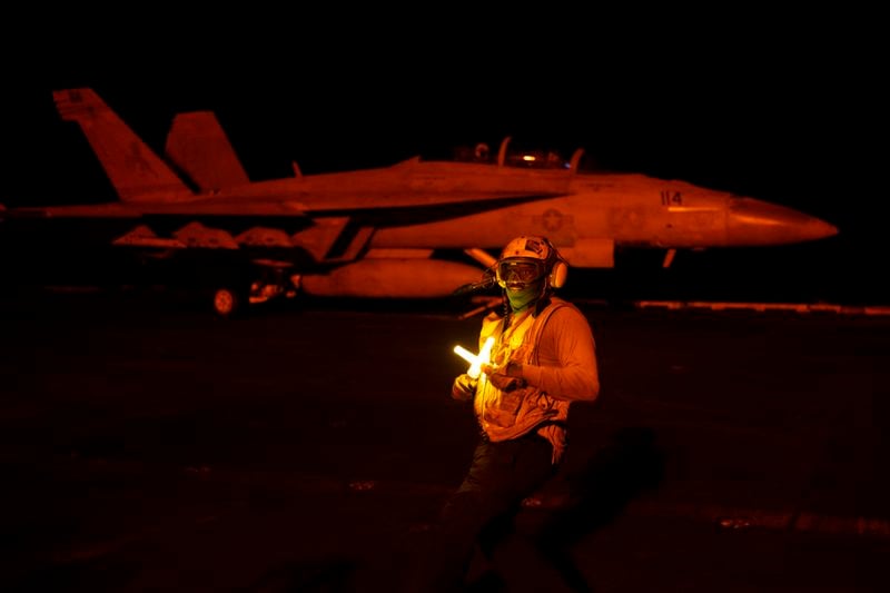 An aircraft handling officer directs a fighter jet during takeoff operations on the deck of the USS Dwight D. Eisenhower in the Red Sea on Tuesday, June 11, 2024. (AP Photo/Bernat Armangue)