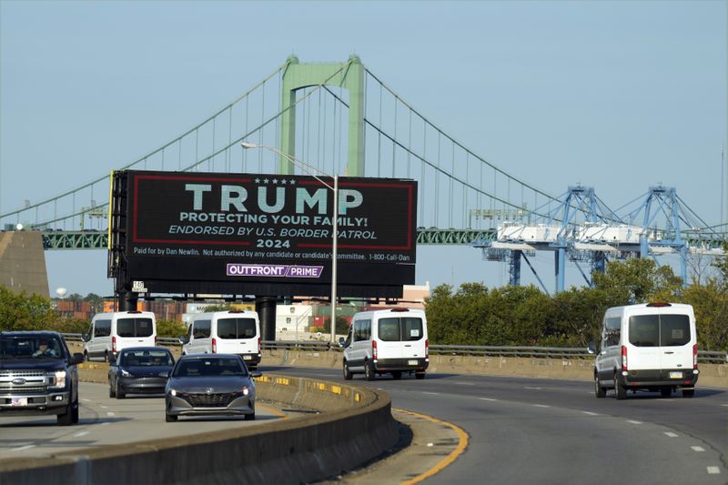 The motorcade of Democratic presidential nominee Vice President Kamala Harris passes a billboard in support of Republican presidential nominee former President Donald Trump Monday, Sept. 9, 2024, ahead of the presidential debate with Republican presidential nominee former President Donald Trump in Philadelphia. (AP Photo/Jacquelyn Martin)