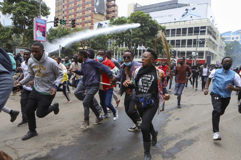 Demonstrators run from police during a protest over proposed tax hikes in a finance bill that is due to be tabled in parliament in Nairobi, Kenya, Thursday, June 20, 2024. (AP Photo/ Andrew Kasuku)