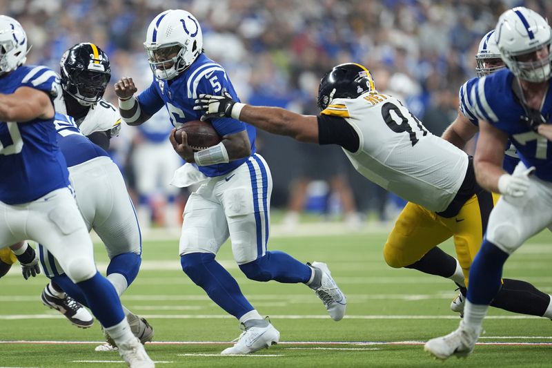 Indianapolis Colts quarterback Anthony Richardson (5) scrambles out of the reach of Pittsburgh Steelers defensive tackle Cameron Heyward (97) during the first half of an NFL football game Sunday, Sept. 29, 2024, in Indianapolis. (AP Photo/Michael Conroy)