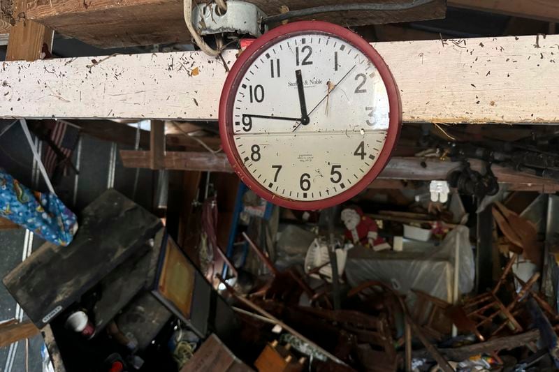 A waterlogged clock hangs a shed, Sunday, Sept 29, 2024, in Steinhatchee, Fla., in the aftermath of Hurricane Helene. (AP Photo/Kate Payne)