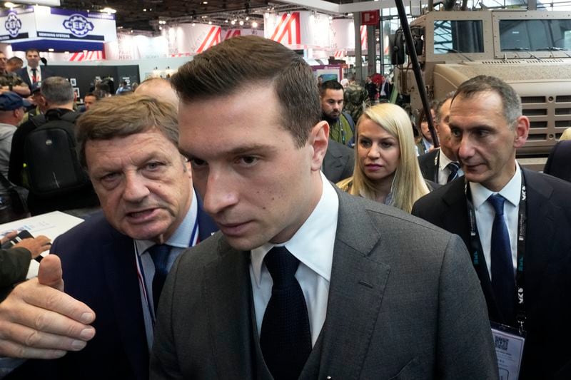 Jordan Bardella, center, president of the far-right National Front party, visits the Eurosatory Defense and Security exhibition, Wednesday, June 19, 2024 in Villepinte, north of Paris. Jordan Bardella, hoping to become France's prime minister, appealed Tuesday to voters to hand his party a clear majority after French President Emmanuel Macron's announcement on June 9 that he was dissolving France's National Assembly, parliament's lower house.( AP Photo/Michel Euler)