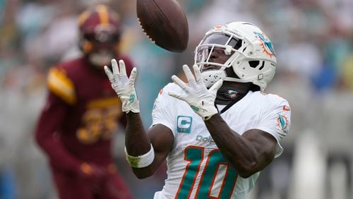 FILE - Miami Dolphins wide receiver Tyreek Hill (10) catches a touchdown pass during the first half of an NFL football game against the Washington Commanders Sunday, Dec. 3, 2023, in Landover, Md. (AP Photo/Mark Schiefelbein, File(