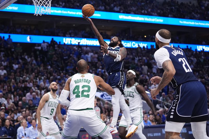 Dallas Mavericks guard Kyrie Irving, center, drives to the basket against the Boston Celtics during the first half in Game 4 of the NBA basketball finals, Friday, June 14, 2024, in Dallas. (AP Photo/Julio Cortez)