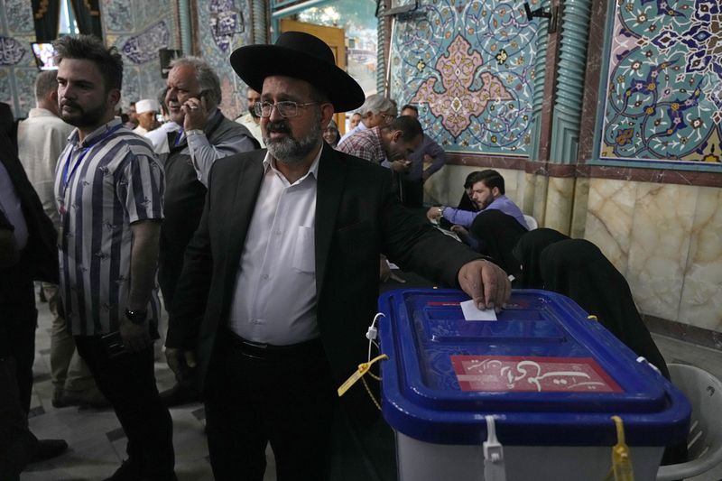 Religious leader of the Iranian Jews Younes Hamami Lalehzar casts his ballot during the presidential election at a polling station in Tehran, Iran, Friday, June 28, 2024. Iranians were voting Friday in a snap election to replace the late President Ebrahim Raisi, killed in a helicopter crash last month, as public apathy has become pervasive in the Islamic Republic after years of economic woes, mass protests and tensions in the Middle East. (AP Photo/Vahid Salemi)