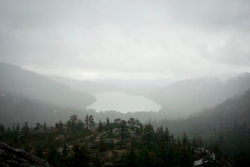 A storm occurs over Donner Lake seen from the Mt. Judah Loop Trail at Sugarbowl Ski Resort Saturday, Aug. 24, 2024, in Donner Summit, Calif. (AP Photo/Brooke Hess-Homeier)