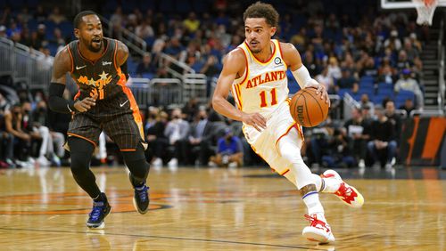 Atlanta Hawks guard Trae Young (11) drives around Orlando Magic guard Terrence Ross (31) during the first half of an NBA basketball game, Wednesday, Dec. 15, 2021, in Orlando, Fla. (AP Photo/John Raoux)