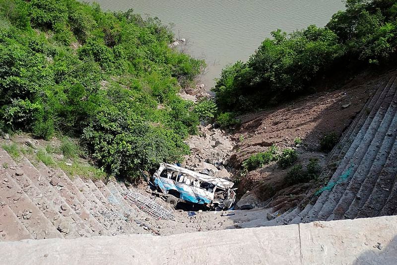 The wreckage of a bus is seen after falling into a ravine, near Kahuta, Pakistan, Sunday, Aug. 25, 2024. (AP Photo/Mohammad Yousaf)