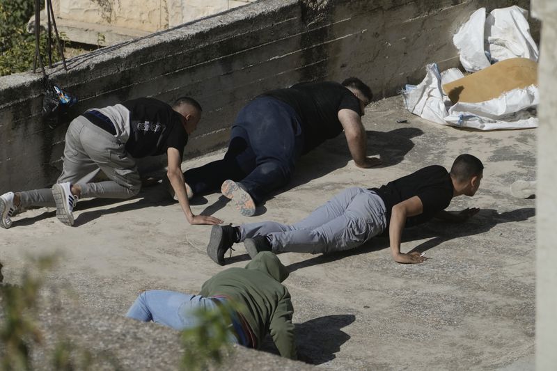 Palestinians duck for cover as the Israeli army raided the northern West Bank town of Qatabiya on Thursday, Sept.19, 2024. (AP Photo/Majdi Mohammed)