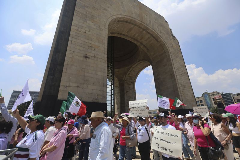 Federal court workers gather outside the Monument to the Revolution as they strike over reforms that would make all judges stand for election in Mexico City, Sunday, Aug. 25, 2024. (AP Photo/Ginnette Riquelme)