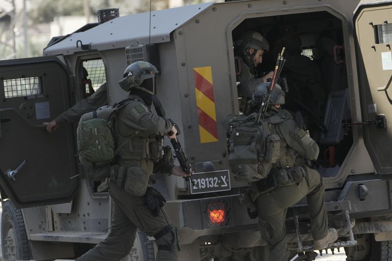 Members of Israeli forces prepare to enter in an armoured vehicle during a military operation in the West Bank refugee camp of Nur Shams, Tulkarem, Thursday, Aug. 29, 2024. (AP Photo/Majdi Mohammed)