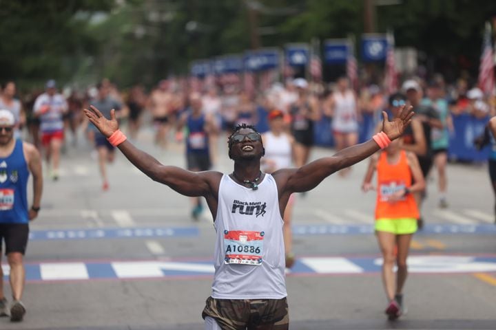 Abass Karbgo celebrates at the finish of the 55th running of the Atlanta Journal-Constitution Peachtree Road Race in Atlanta on Thursday, July 4, 2024.   (Jason Getz / AJC)