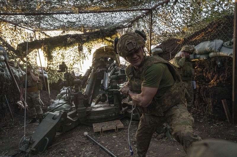 A Ukrainian serviceman Oleh of 148th separate artillery brigade of the Air Assault Forces fires towards Russian positions by a M777 howitzer at the frontline in Donetsk region, Ukraine, Wednesday, August 21, 2024. (AP Photo/Evgeniy Maloletka)