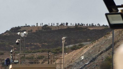 People thought to be migrants stand on top of hill at the Tarajal border in the Spanish enclave of Ceuta, Sunday, Sept. 15, 2024. (Antonio Sempera/Europa Press via AP)