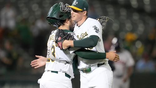 Oakland Athletics catcher Shea Langeliers, left, celebrates with pitcher Mason Miller after the Athletics defeated the Houston Astros in a baseball game in Oakland, Calif., Monday, July 22, 2024. (AP Photo/Jeff Chiu)