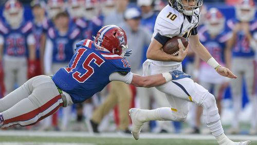 Marist quarterback Champ Davis (10) carries the ball for yardage as Jefferson’s Austin Redmon (15) attempts the tackle during the first half of their Class 4A state high school football final Tuesday, December 29, 2020 in Atlanta. (PHOTO/Daniel Varnado)