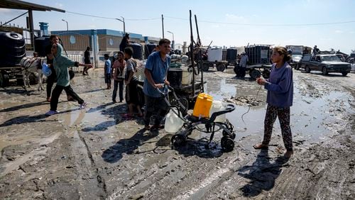 Palestinians gather to fill water jugs at a makeshift tent camp in Deir al-Balah, central Gaza Strip, Thursday, Aug. 29, 2024. (AP Photo/Abdel Kareem Hana)