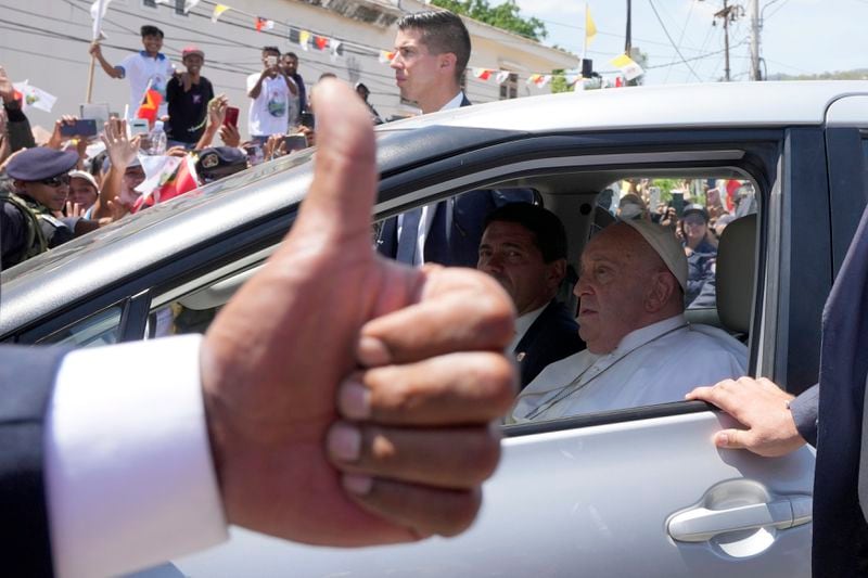 People greet Pope Francis as he travels in a car in Dili, East Timor, Tuesday, Sept. 10, 2024. In East Timor Francis had to negotiate perhaps the most sensitive issue clouding the visit to Asia and Oceania : the case of Bishop Carlos Ximenes Belo, the revered national hero who won the Nobel Peace Prize for his nonviolent independence campaign. (AP Photo/Firdia Lisnawati)