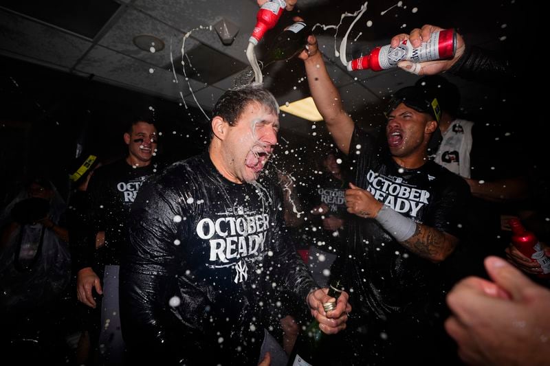 New York Yankees relief pitcher Tommy Kahnle, left, celebrates clinching a playoff spot with teammates after a 2-1 win over the Seattle Mariners in 10 innings in a baseball game Wednesday, Sept. 18, 2024, in Seattle. (AP Photo/Lindsey Wasson)