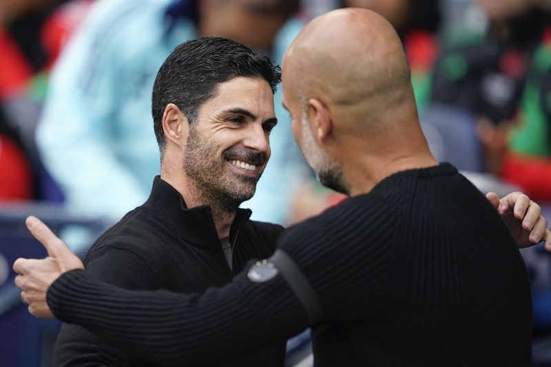 Arsenal's manager Mikel Arteta, left, embraces Manchester City's head coach Pep Guardiola before the English Premier League soccer match between Manchester City and Arsenal at the Etihad stadium in Manchester, England, Sunday, Sept. 22, 2024. (AP Photo/Dave Thompson)