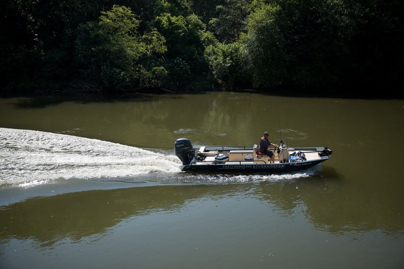 Jason Ulseth, the executive director of the Chattahoochee Riverkeeper,  navigates a boat down the Chattahoochee River on June 12, 2024.