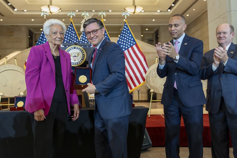 House Speaker Mike Johnson, R-La., center, presents a Congressional Gold Medal to Ann Hammond, daughter of NASA's Dorothy Vaughan, at a ceremony to honor the Black women mathematicians of NASA who contributed to the space race and who were the subject of the book and movie "Hidden Figures," at the Capitol in Washington, Wednesday, Sept. 18, 2024. They are joined by House Minority Leader Hakeem Jeffries, D-N.Y., second from right, and Sen. Chris Coons, D-Del. (AP Photo/J. Scott Applewhite)