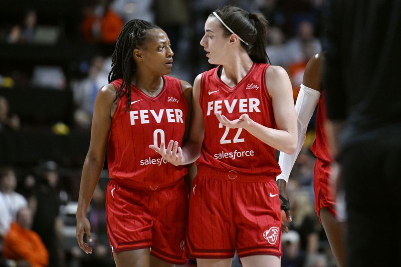 Indiana Fever guards Kelsey Mitchell (0) and Caitlin Clark (22) talks during the first half in Game 2 of a first-round WNBA basketball playoff series against the Connecticut Sun, Wednesday, Sept. 25, 2024, in Uncasville, Conn. (AP Photo/Jessica Hill)