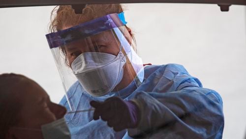 08/27/2020 - Doraville, Georgia -  Nurse Kellie Kinard of the Jackson Nurse Professionals performs a COVID-19 test on a patient at a DeKalb County Board of Health drive-thru COVID-19 testing site in the parking lot of a closed K-Mart in Doraville, Thursday, August 27, 2020. (ALYSSA POINTER / ALYSSA.POINTER@AJC.COM)