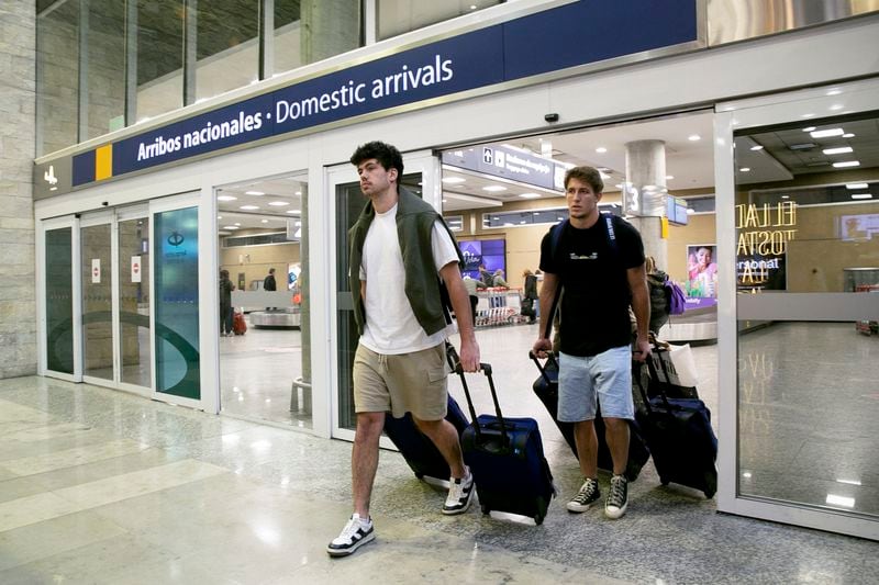 French rugby players Oscar Jegou, right, and Hugo Auradou arrive from Mendoza at the airport in Buenos Aires, Argentina, Tuesday, Aug. 27, 2024. The players were arrested following charges of sexual assault after France played Argentina in Mendoza on July 6. (AP Photo/Virginia Chaile)