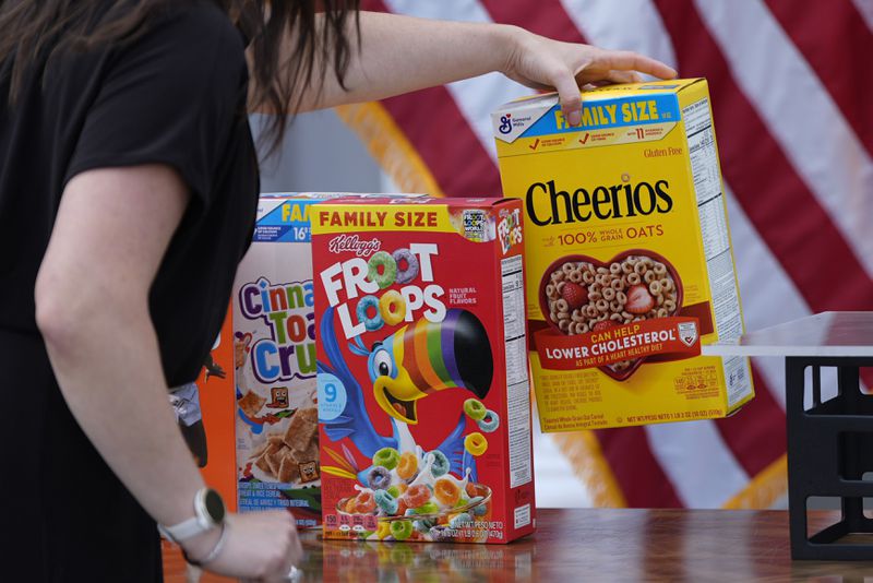 A staffer arranges boxes of cereal on a table display before Republican presidential nominee former President Donald Trump speaks at a news conference at Trump National Golf Club, Thursday, Aug. 15, 2024, in Bedminster, N.J. (AP Photo/Julia Nikhinson)