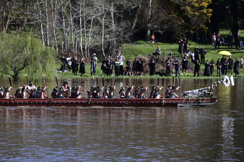 A waka, a traditional canoe, is paddled by warriors as part of the funeral of New Zealand's Maori King, Kiingi Tuheitia Pootatau Te Wherowhero VII, in Ngaruawahia, New Zealand, Thursday, Sept. 5, 2024. (AP Photo/Alan Gibson)