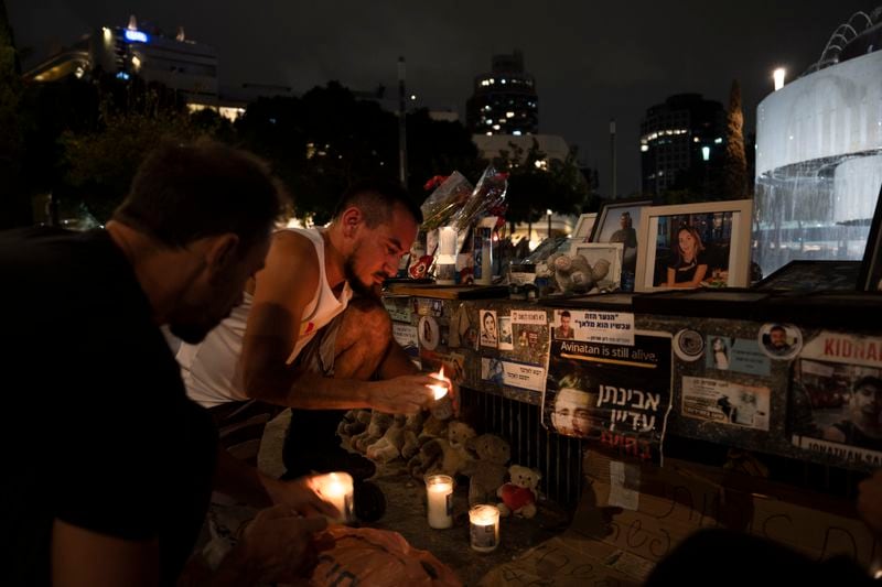 People light candles at a memorial for the victims of the Oct. 7 Hamas cross-border attack on Israel, on the eve of the one-year anniversary of the attack, in Tel Aviv, Israel, Sunday, Oct. 6, 2024. (AP Photo/Oded Balilty)