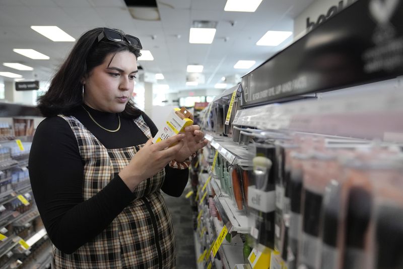 Daniella López White, of Hawaii, shops in the makeup and skincare isle of a CVS Pharmacy, Tuesday, May 14, 2024, in Boston. López White, who graduated from Emerson College in Boston this month and is on a tight budget, said TikTok influencers have helped her with tips on how to find affordable clothes at places like H&M and thrift shops. She buys makeup brands at CVS based on influencer advice. (AP Photo/Steven Senne)